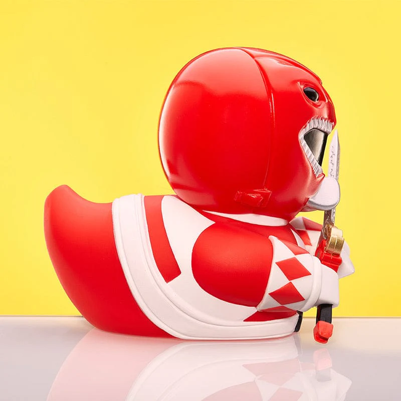 Egy gumikacsa, amely piros Power Ranger-nek öltözött, fegyvert tartva.