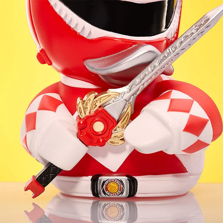 Egy piros Power Ranger figura ezüst karddal, sárga háttér előtt.