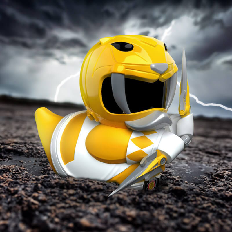 Sárga Power Ranger kacsa karddal sötét talajon, viharos ég a háttérben.