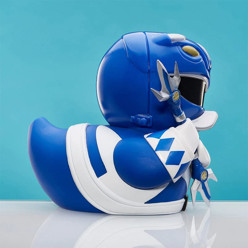 Kék Power Rangers kacsa játék fehér mellrésszel és sisak részletekkel, kék háttérrel.