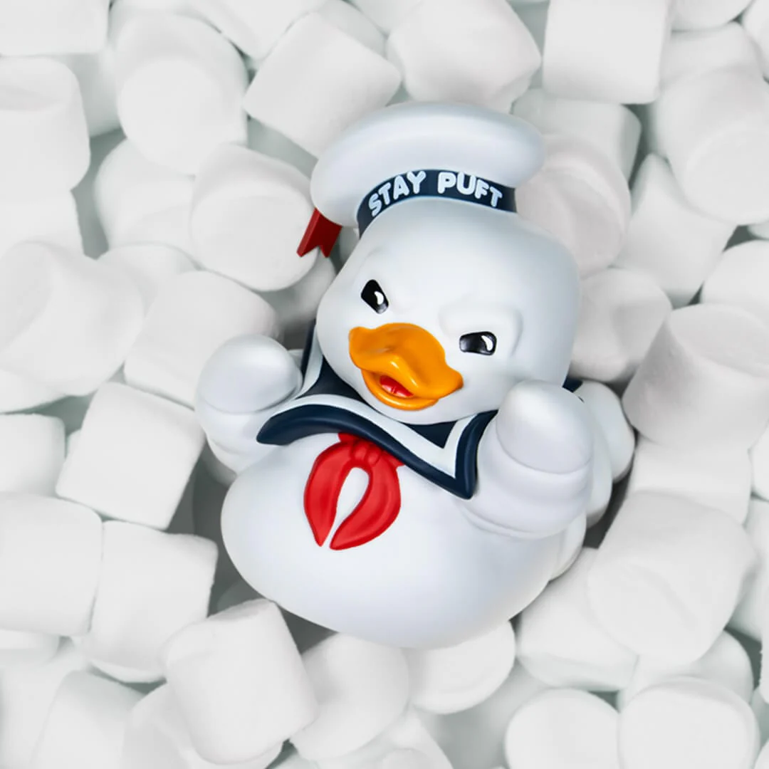 Egy fehér Stay Puft Marshmallow Man játék, amelyet pillecukrok vesznek körül.