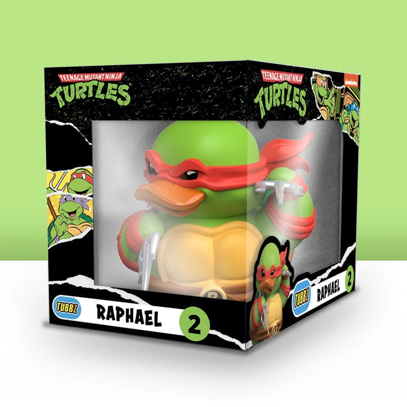 Egy Teenage Mutant Ninja Turtle figura egy dobozban. A figura zöld és piros. A dobozon szöveg van.