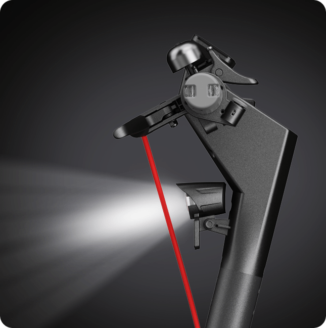 Czarne urządzenie z czerwoną wiązką lasera i jasnym światłem na ciemnym tle.