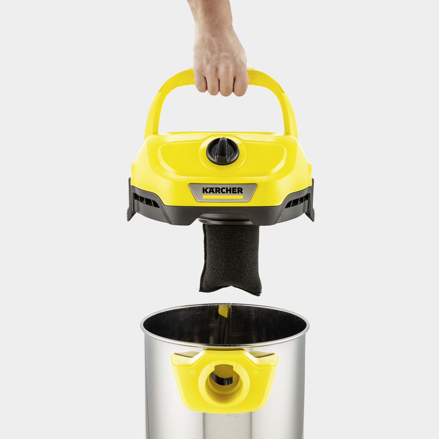 Yellow vacuum cleaner head being held above a silver canister. Black filter.