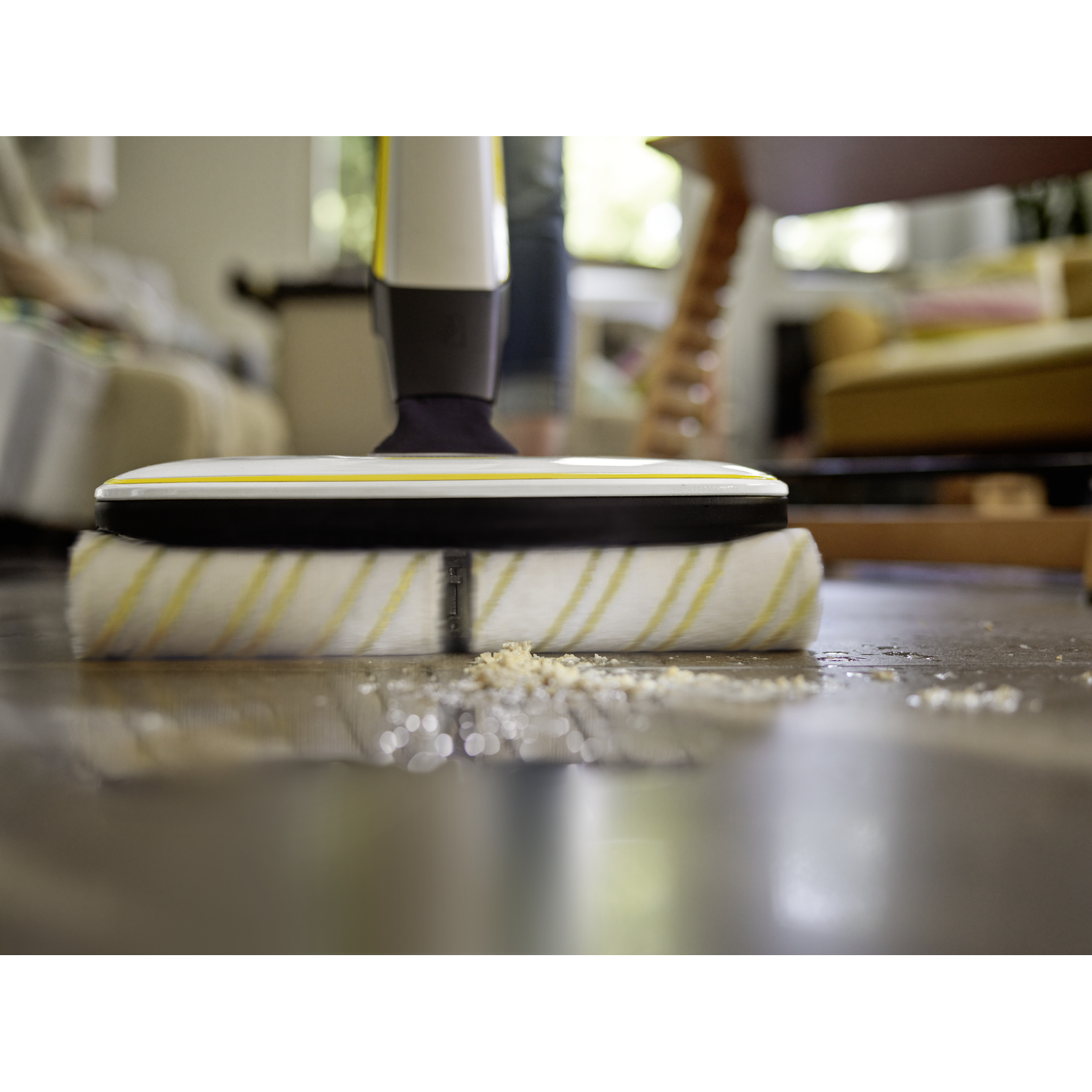 A vacuum cleaner head with a yellow and white roller cleaning a floor.