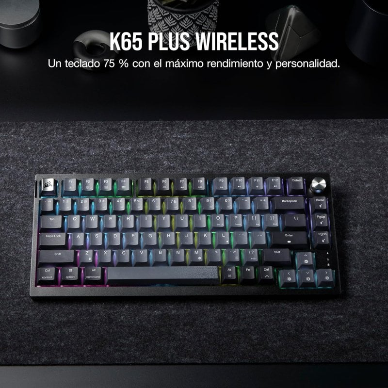 Un teclado negro con teclas arcoíris, sobre una superficie oscura con texto arriba.