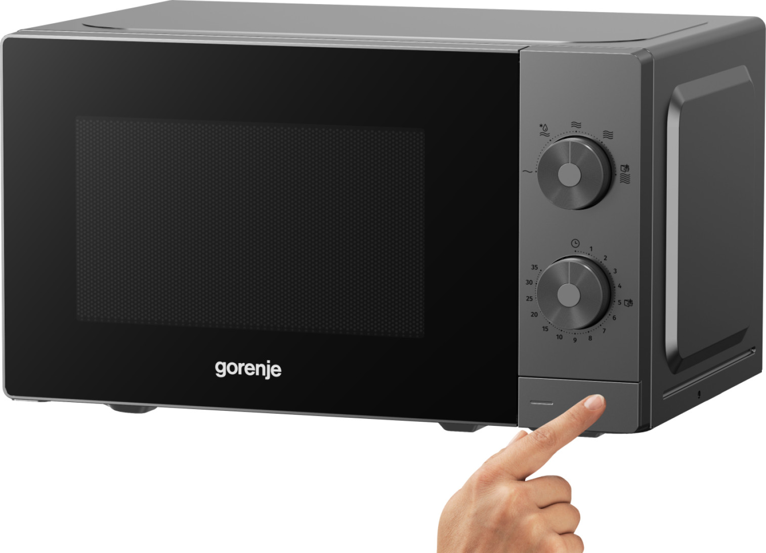 Szary piekarnik mikrofalowy z ręką naciskającą przycisk na dole.