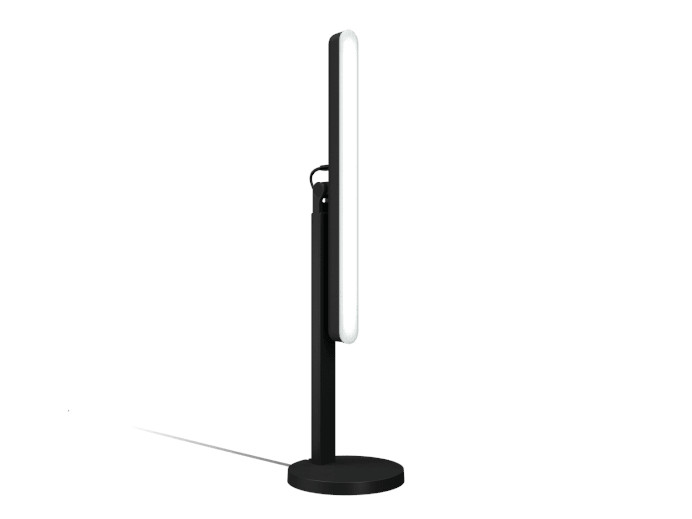 Czarna lampa stojąca z białym, podświetlanym panelem. Podstawa jest okrągła. Panel jest po prawej.