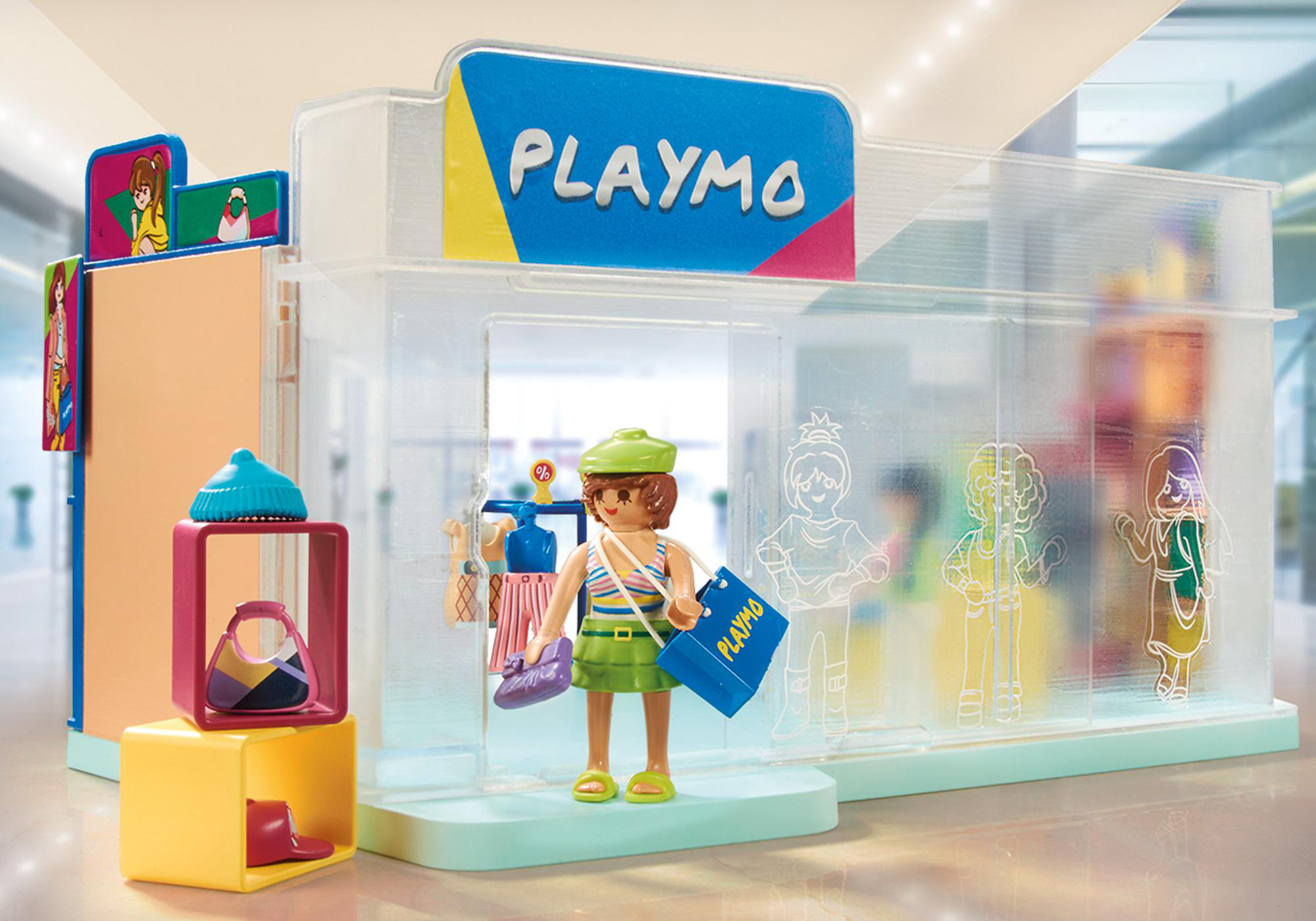 Playmobil-Spielzeugladen-Szene. Eine Mädchenfigur mit Einkaufstaschen steht vor einem Laden mit anderen Figuren.