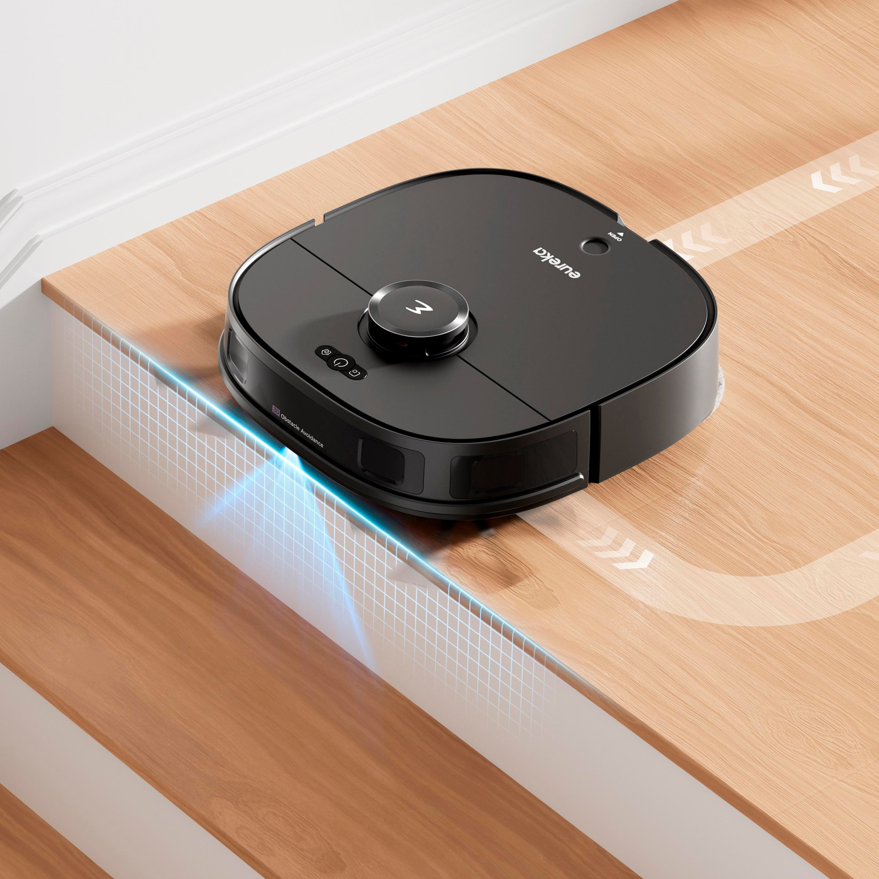 Ein schwarzer Eureka-Roboter-Staubsauger auf einem Holzboden, der reinigt.