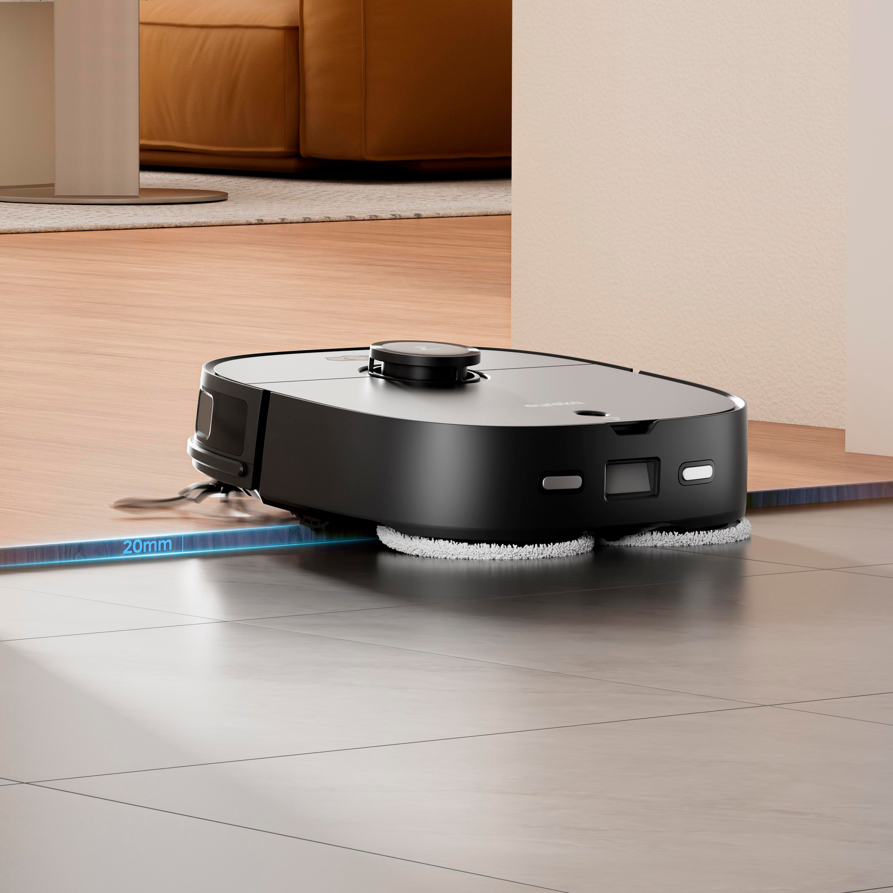 Schwarzer Roboter-Staubsauger auf Fliesenboden, Hintergrund Holzfußboden und Sofa.