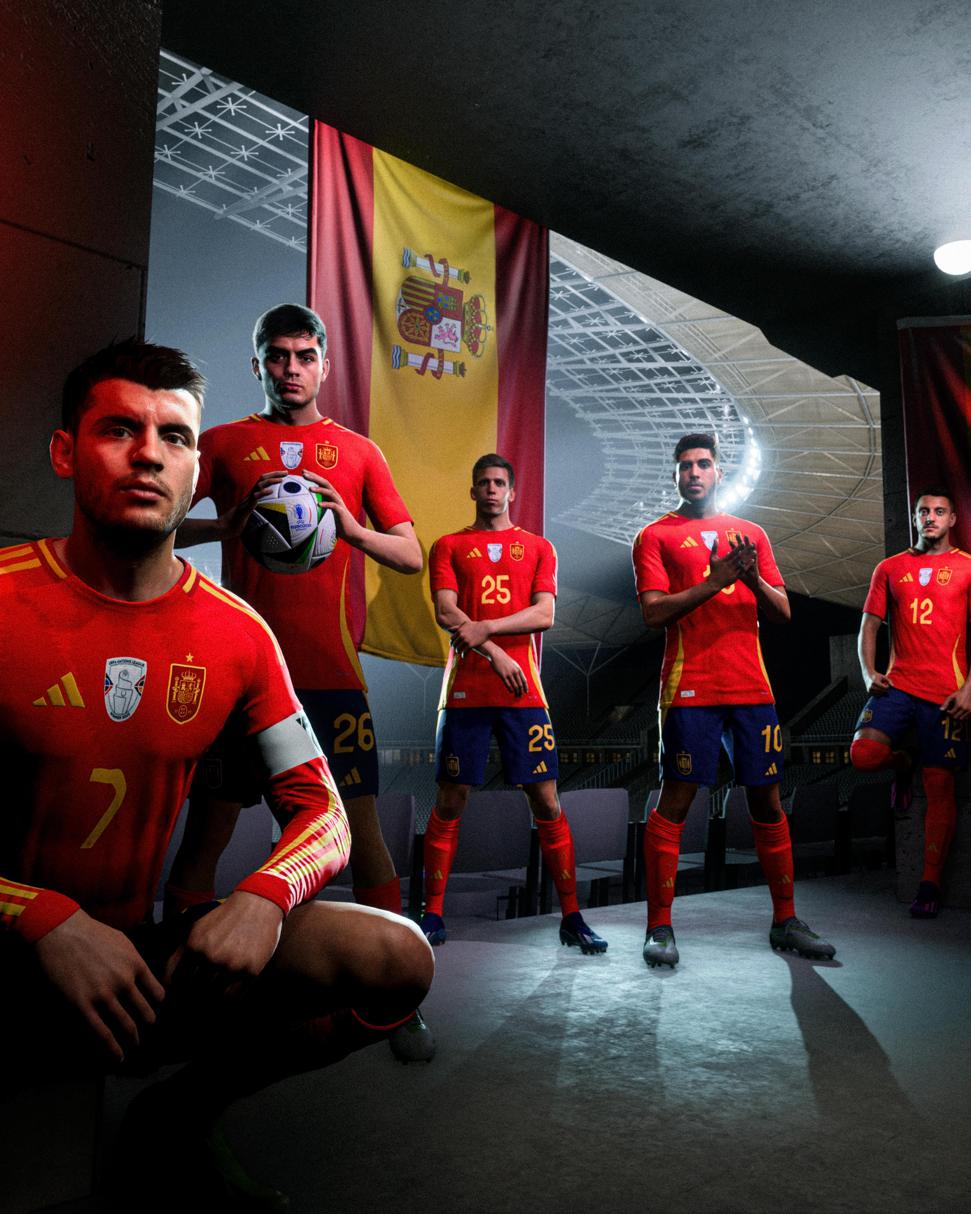 Fußballteam posiert. Rote Trikots, Shorts und die spanische Flagge im Hintergrund. Spieler im Stadion.