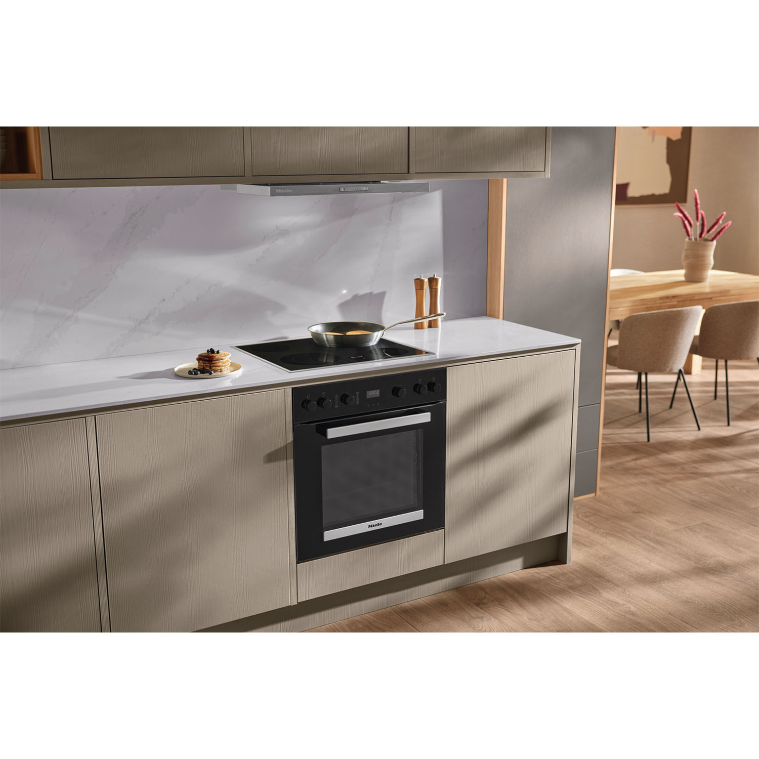 Cucina con forno Miele, piano cottura e vista sulla zona pranzo.