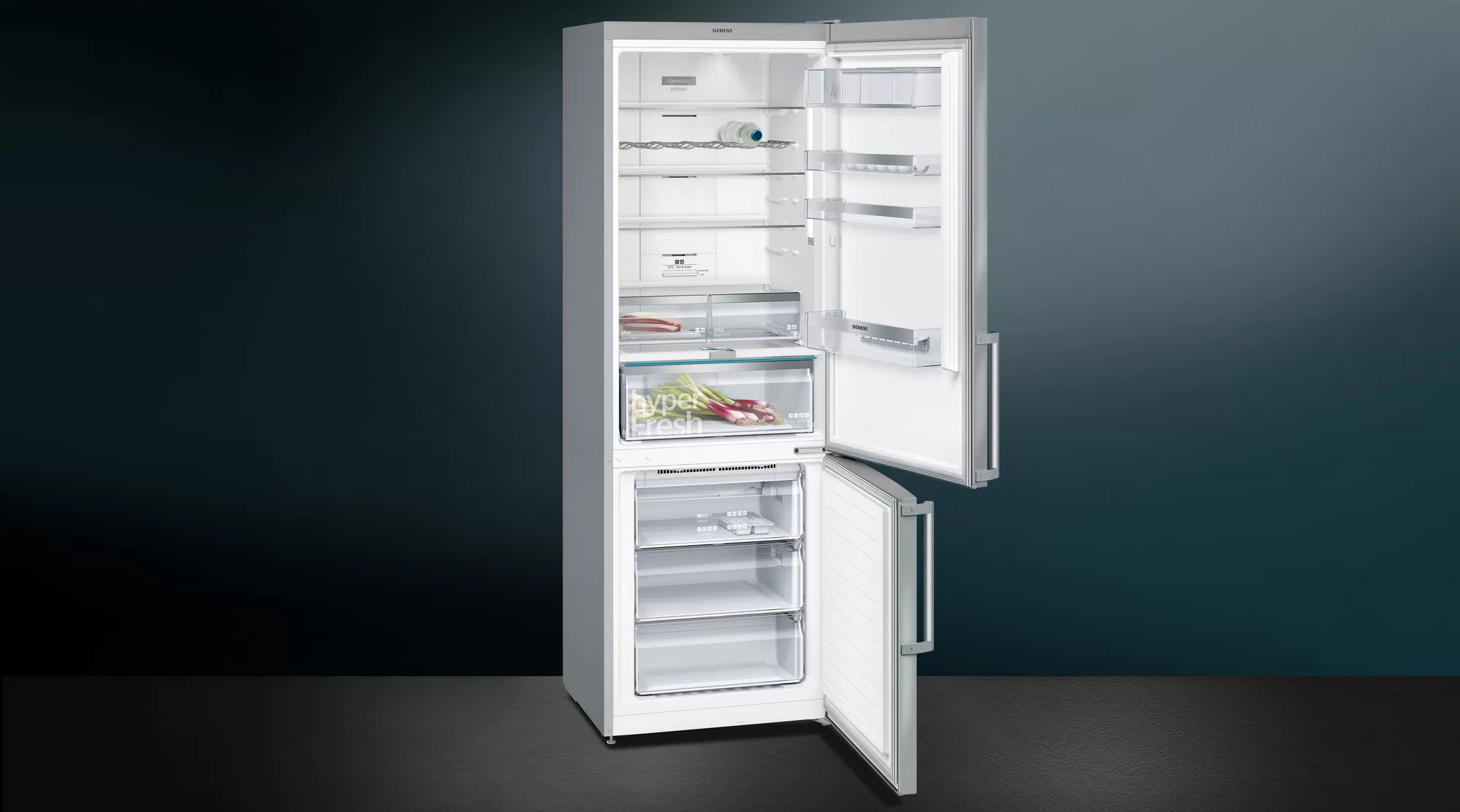 Otwarty środek lodówki z półkami, szufladami i dwoma dzbankami mleka.