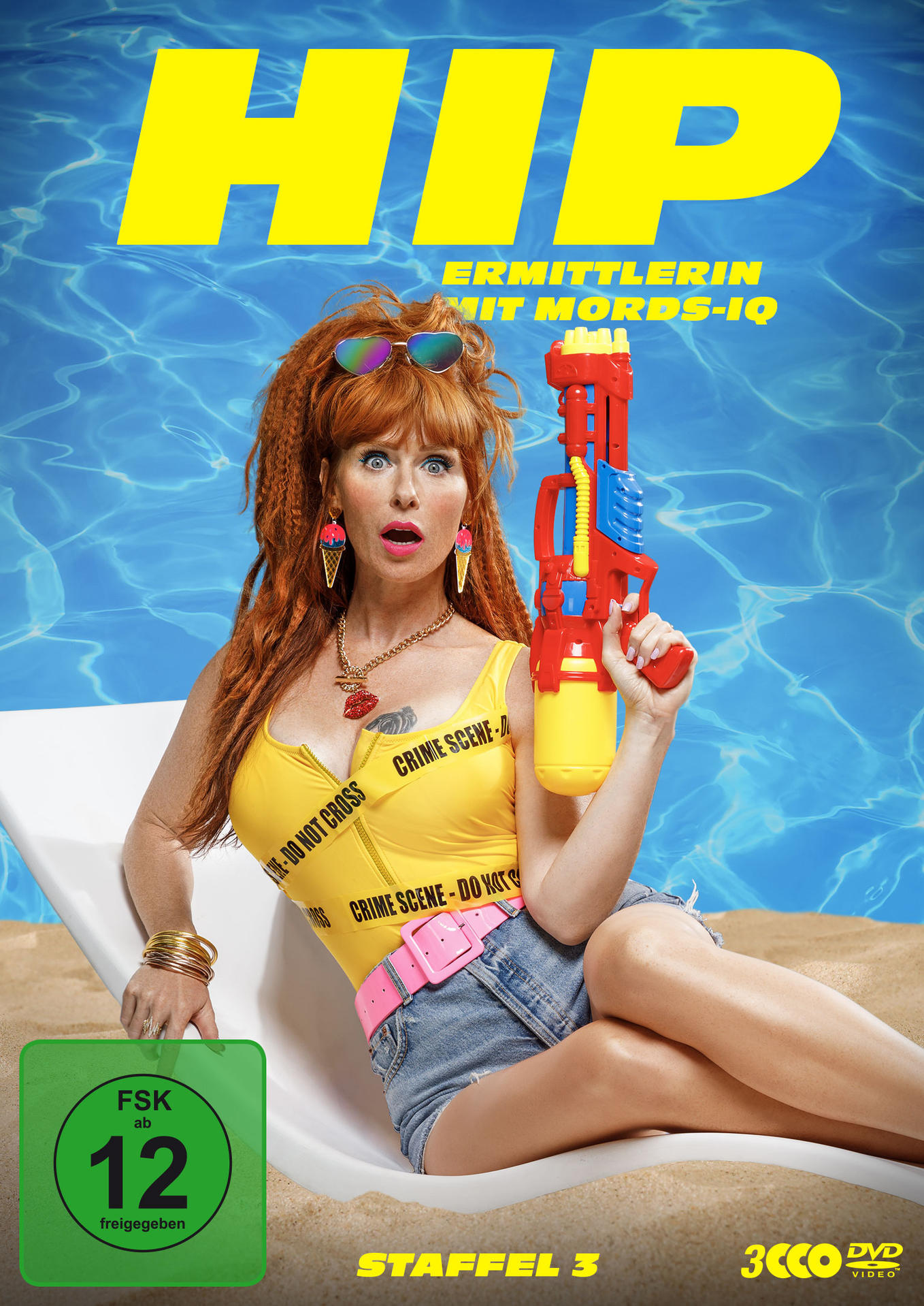 DVD-Cover mit einer Frau in gelbem Top, die eine Spielzeugpistole am Strand hält. Text auf Deutsch.