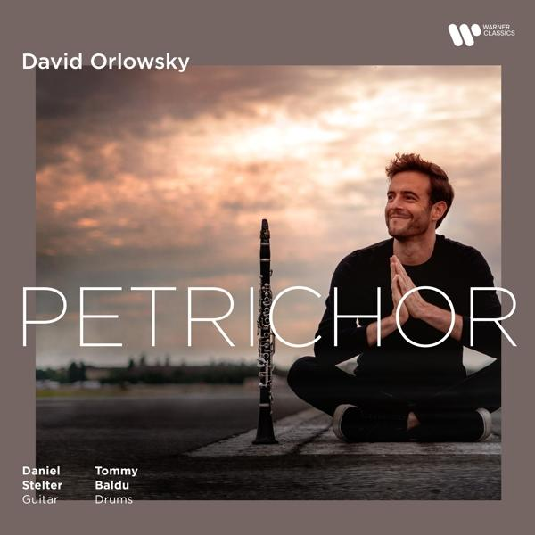 Albumcover: David Orlowsky mit Klarinette. Mann sitzt, Hände zusammen, auf einem Feld.