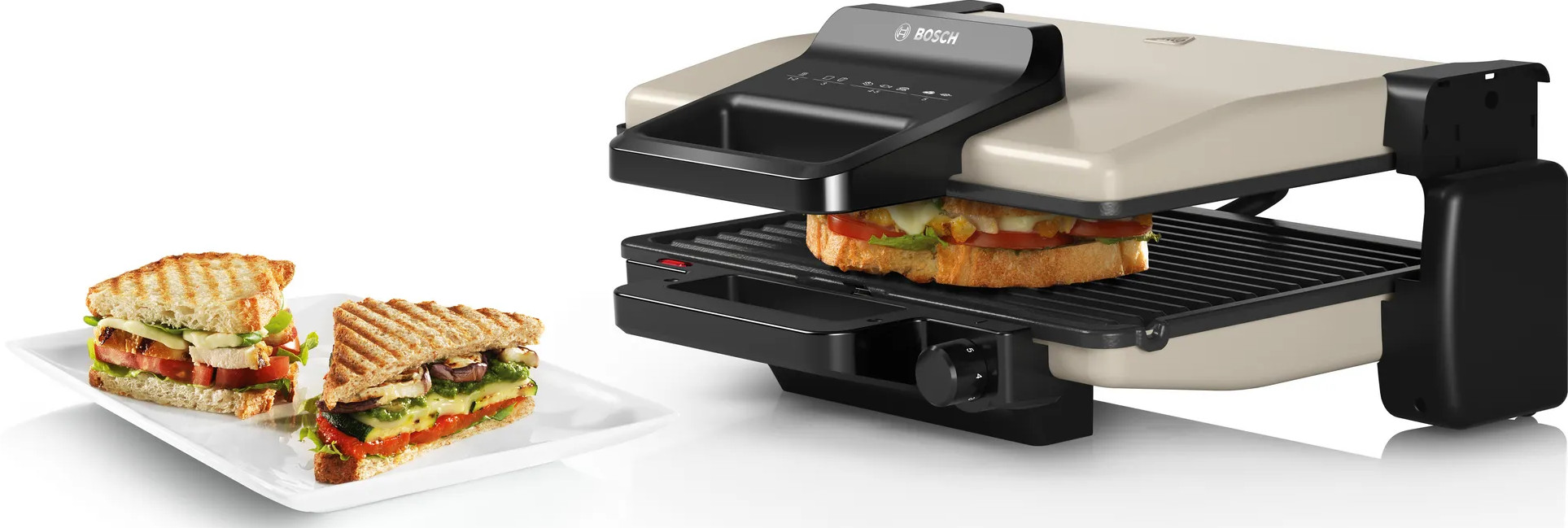 Grill z dwiema kanapkami i grillowaną kanapką. Grill jest otwarty.