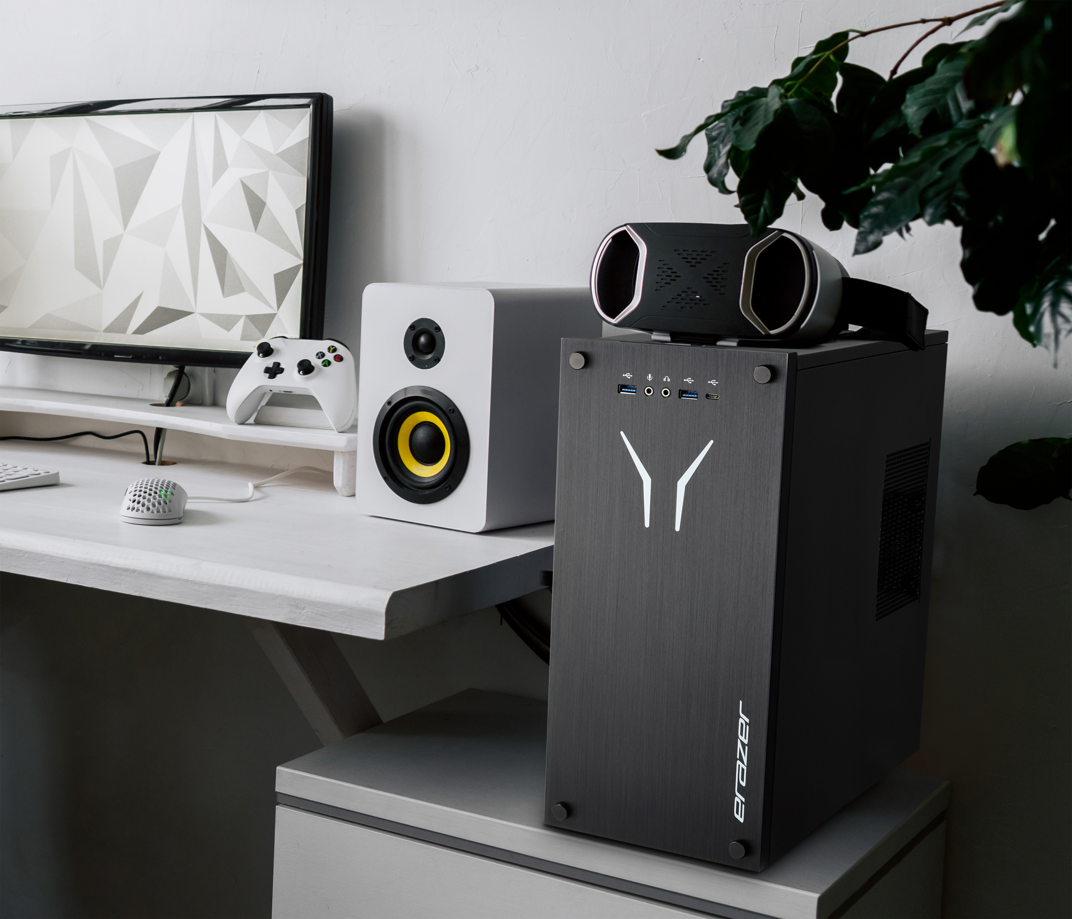 Configuration de jeu. Comprend un ordinateur, des haut-parleurs blancs, une manette de jeu, un casque VR et une souris.