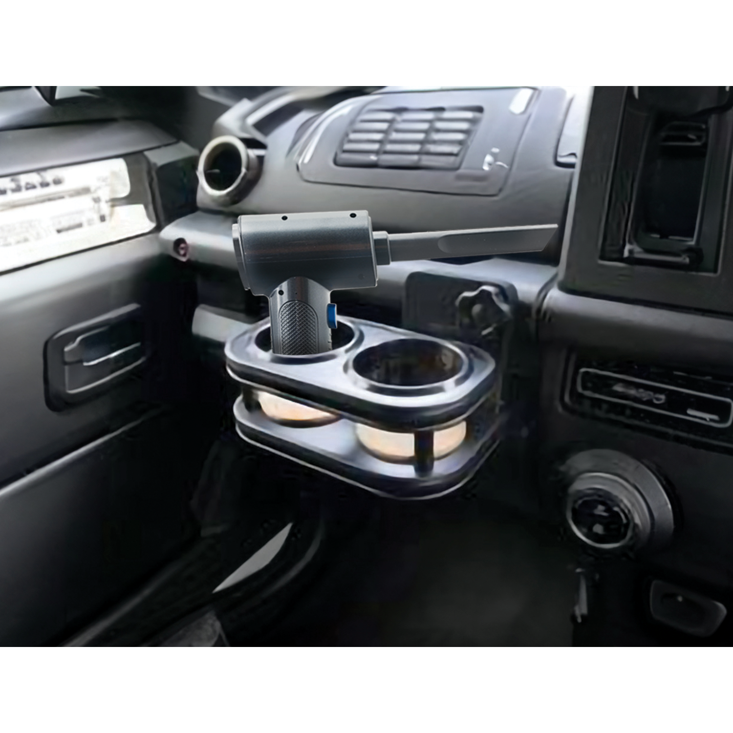 A car interior with a cup holder and a small vacuum.