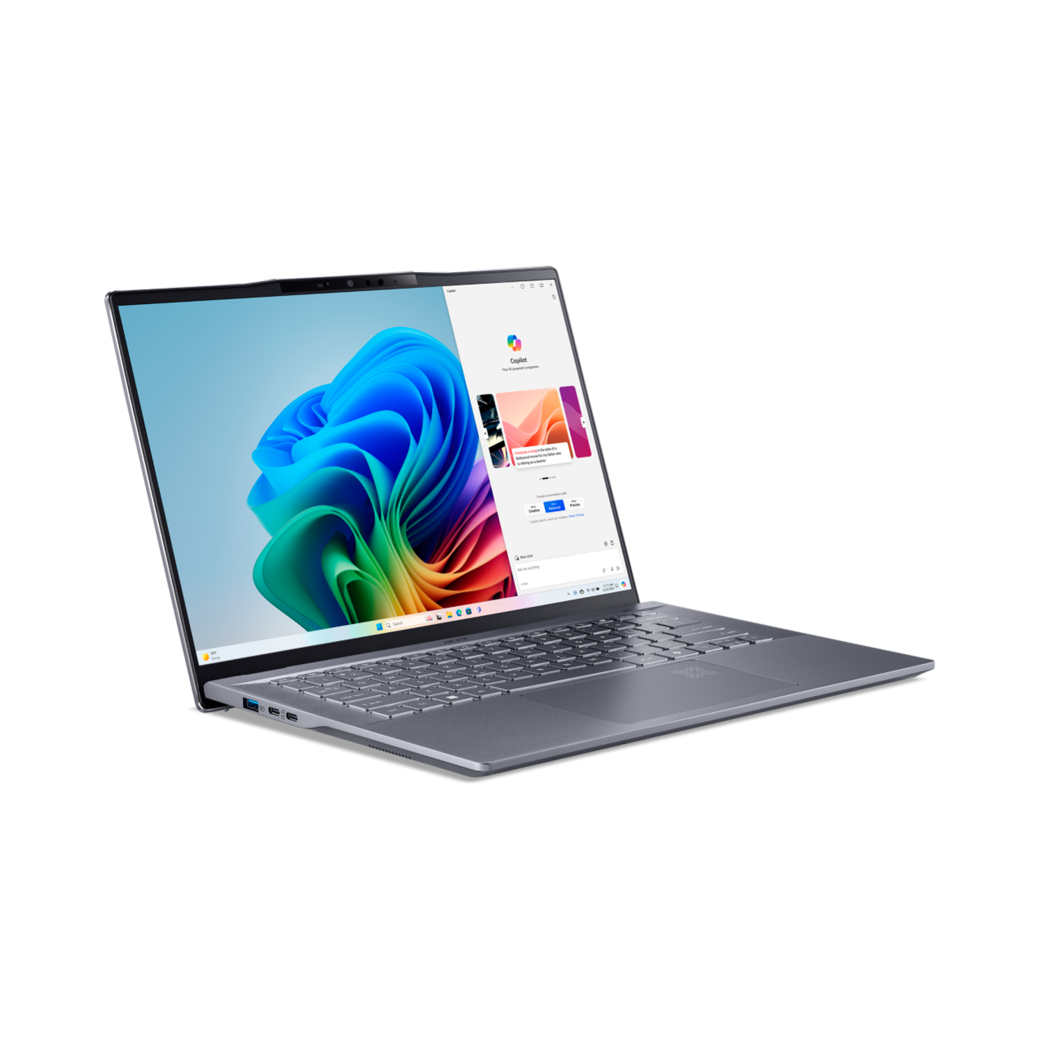 A grey laptop is open on a black surface, displaying colorful graphics on the screen.