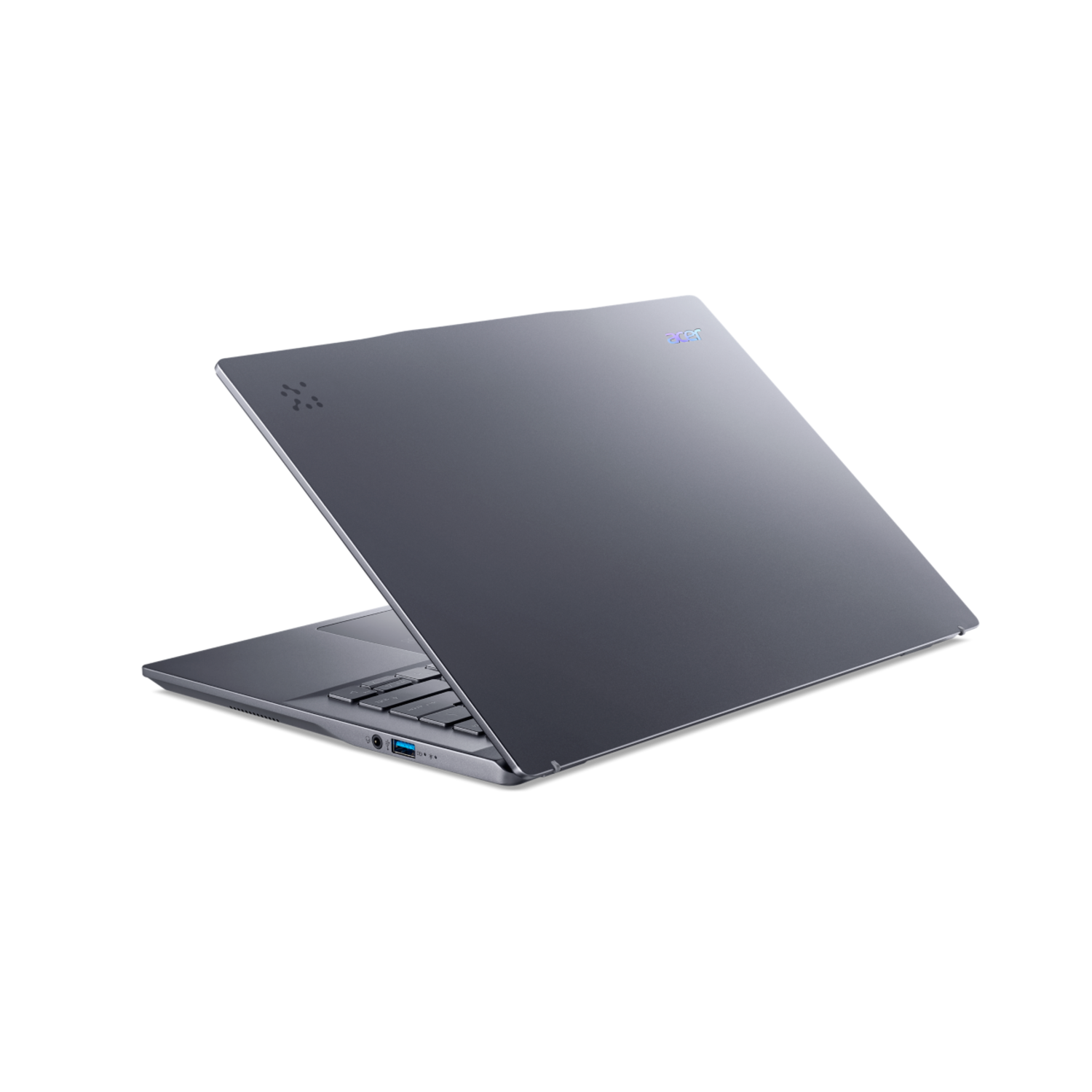 A gray laptop, open and angled on a black surface, with a keyboard visible. Back view.