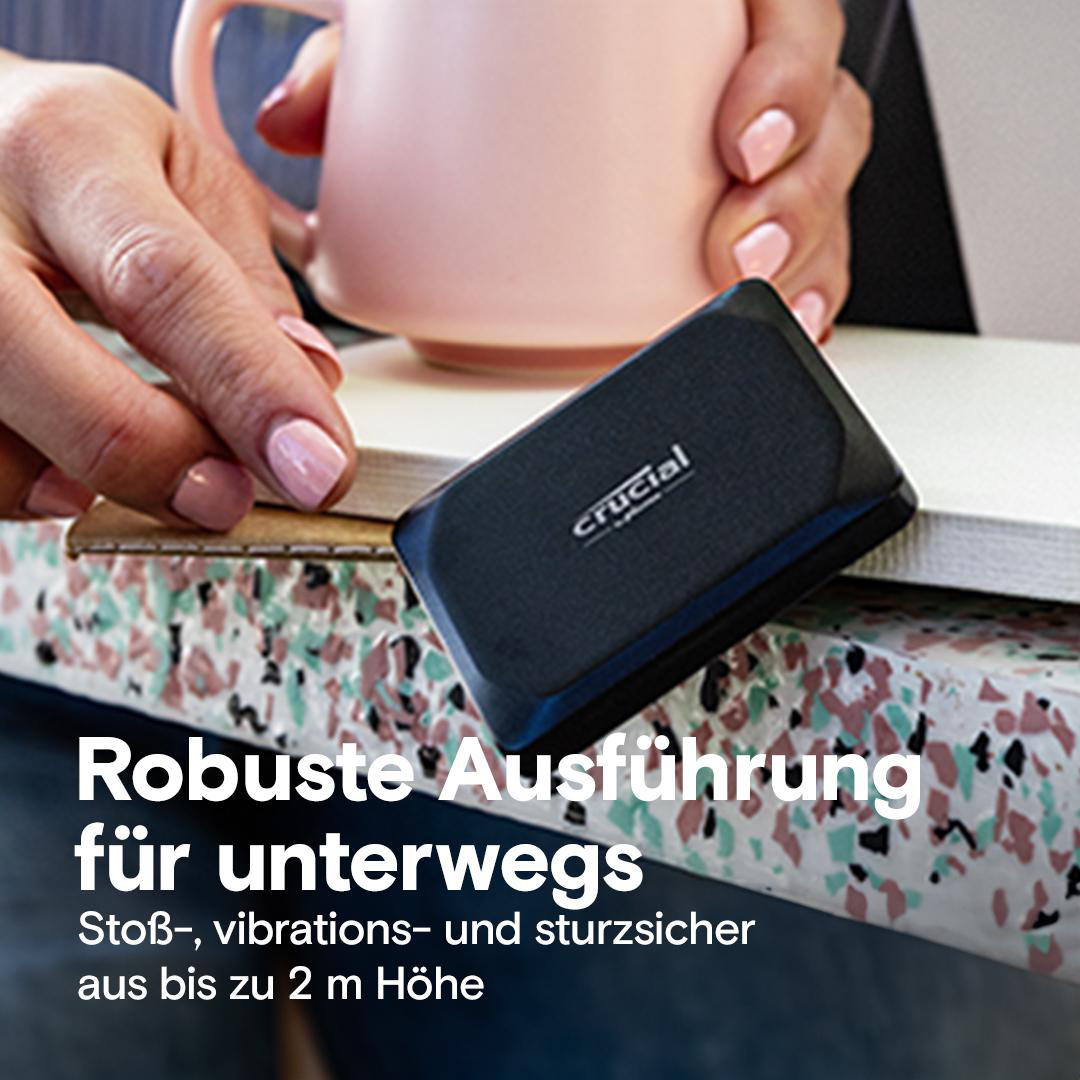 Die Hände einer Person halten eine schwarze Crucial externe SSD. Text: 'Robustes Design für unterwegs'.