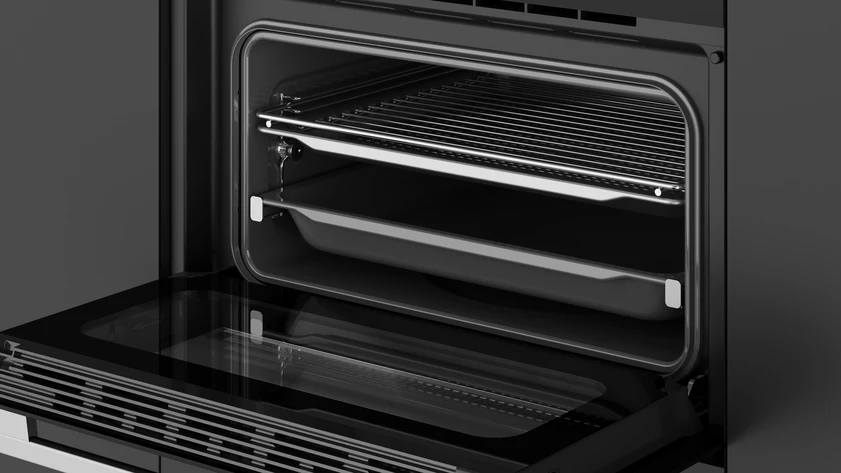 Un horno abierto con rejillas y una bandeja dentro, sobre un fondo gris oscuro.