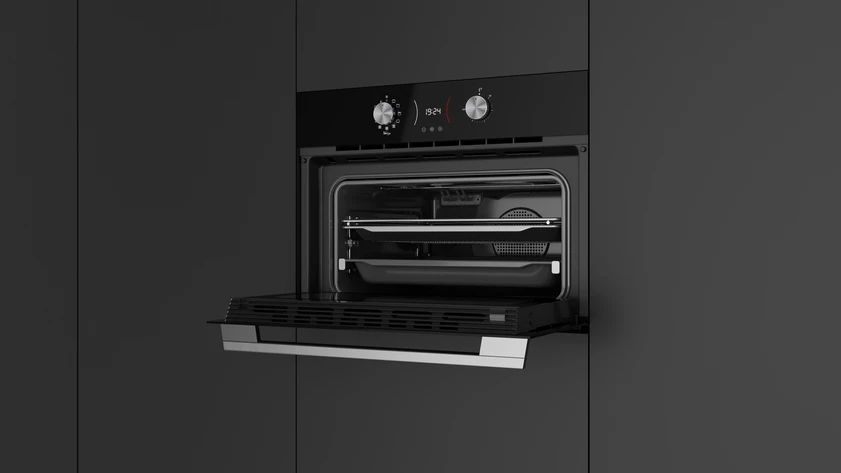 Horno negro abierto con estantes dentro. La puerta está abierta. La pared es gris oscuro.