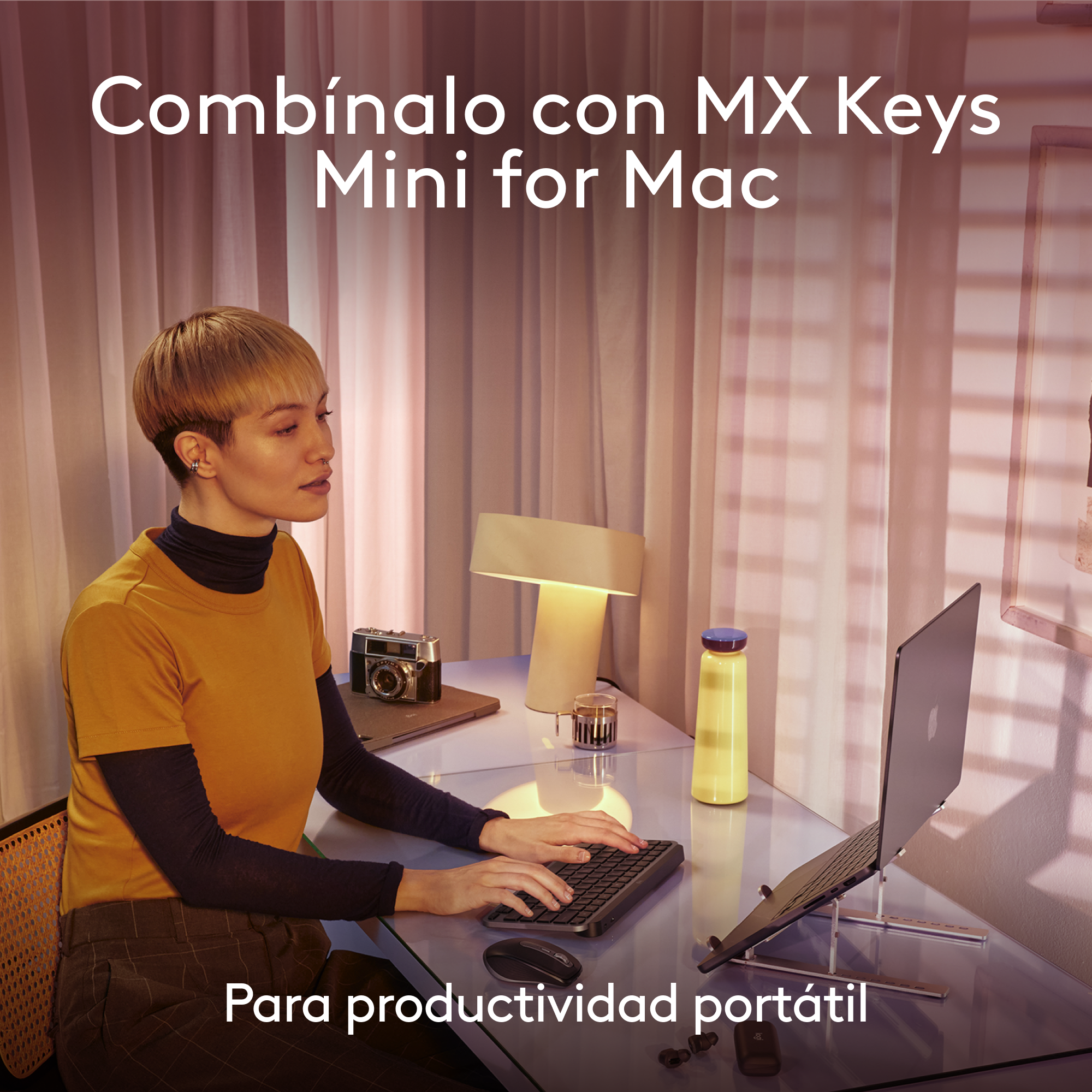 Una mujer usando una laptop con teclado y ratón en un escritorio de cristal.