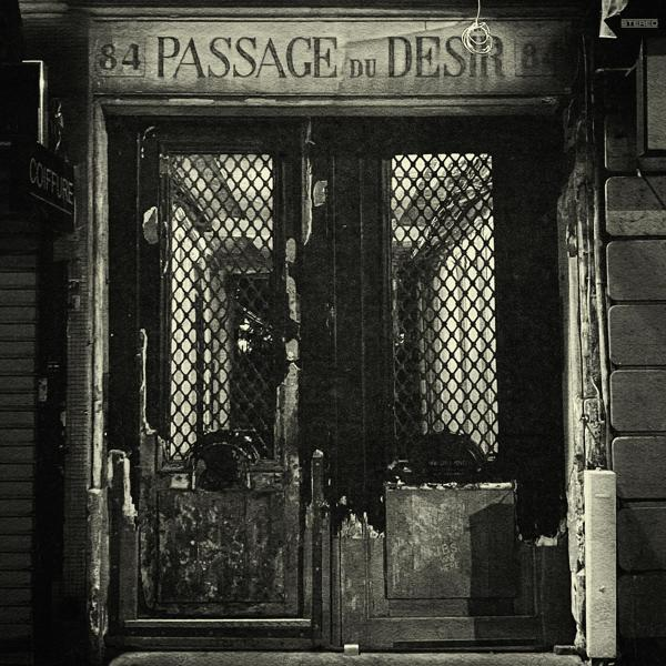 Schwarz-Weiß-Bild einer verwitterten Tür mit der Aufschrift 'PASSAGE DU DESIR'.