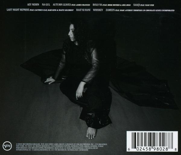Frau sitzt mit verschränkten Beinen, in Schwarz, mit Albumcover-Text und Barcode.
