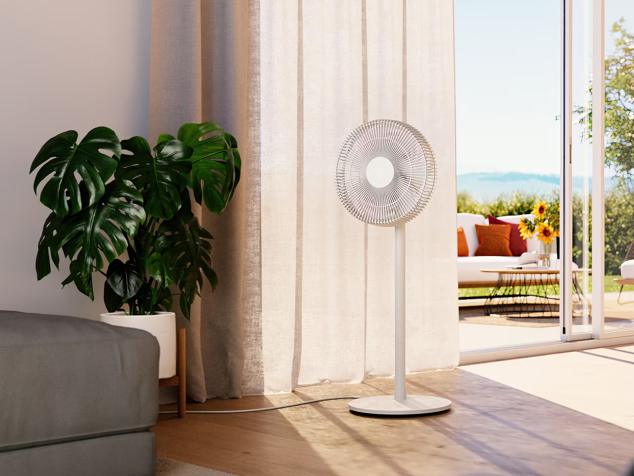 Ein weißer Standventilator in einem modernen Wohnzimmer mit einer grünen Pflanze und geöffneten Türen zu einer sonnigen Terrasse.