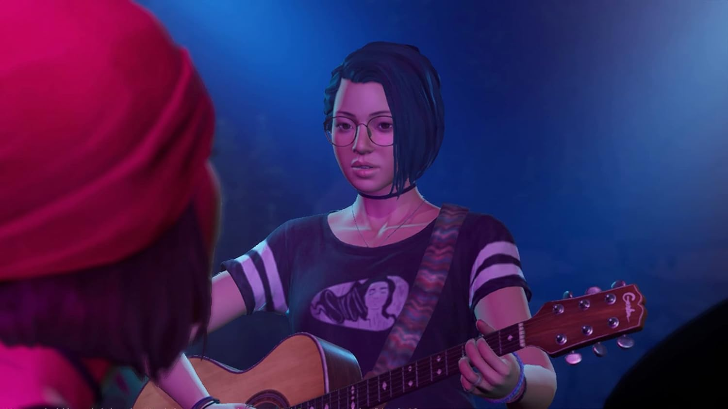 Mujer tocando la guitarra en el escenario, otra persona presente.