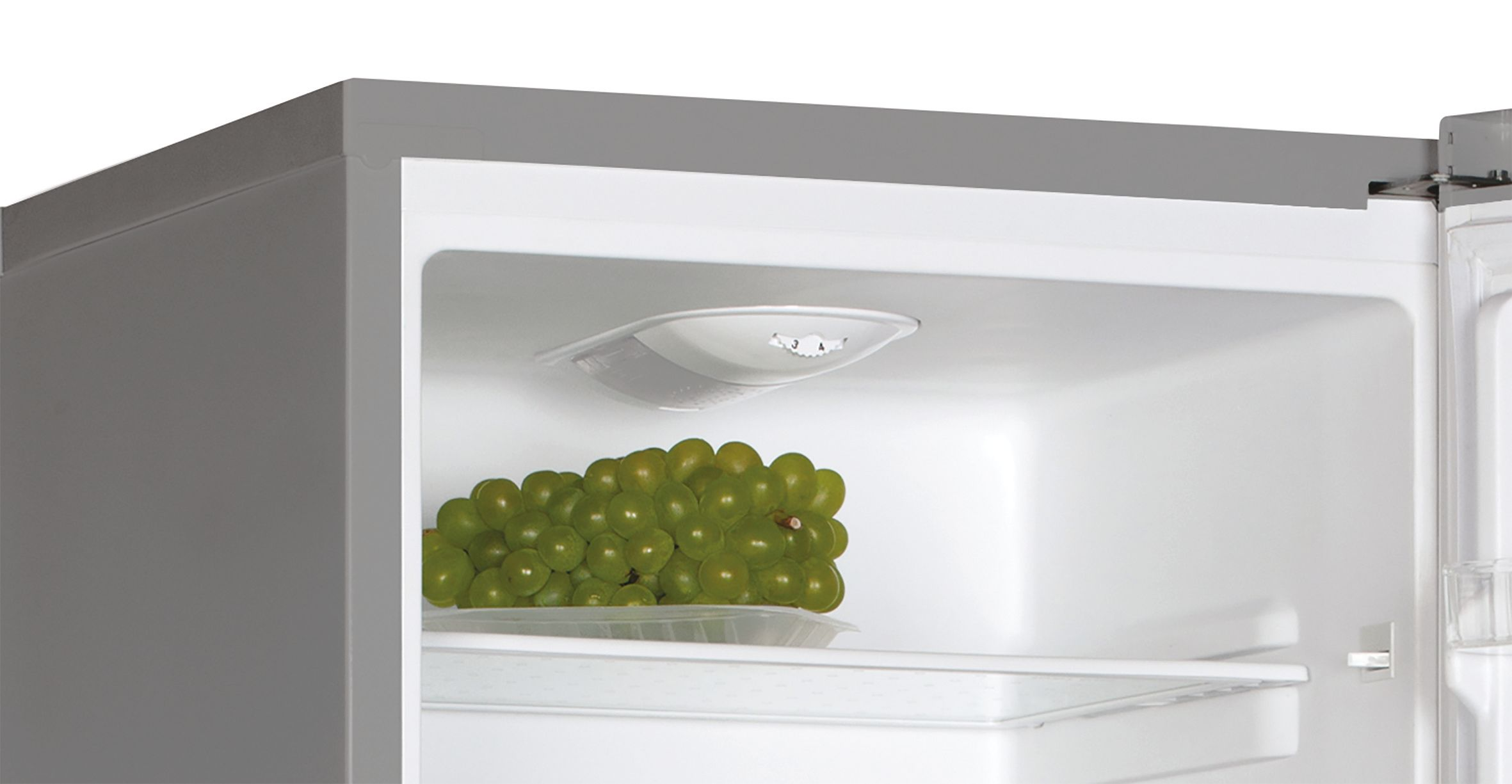 Dentro de la nevera: uvas en un recipiente, una repisa y una luz.