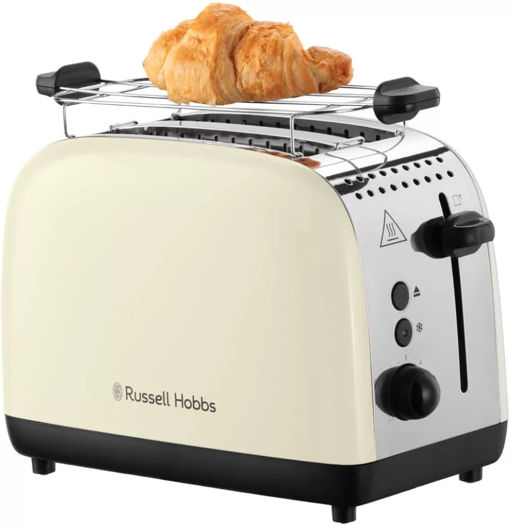 Un tostapane color crema con un croissant sopra, su sfondo bianco.