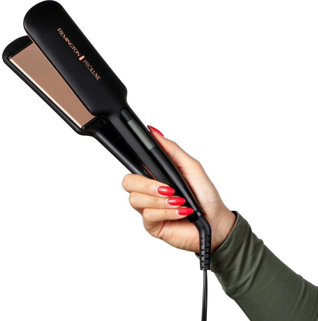 Una mano che tiene una piastra per capelli nera. La piastra ha l'etichetta 'Remington PROluxe'.