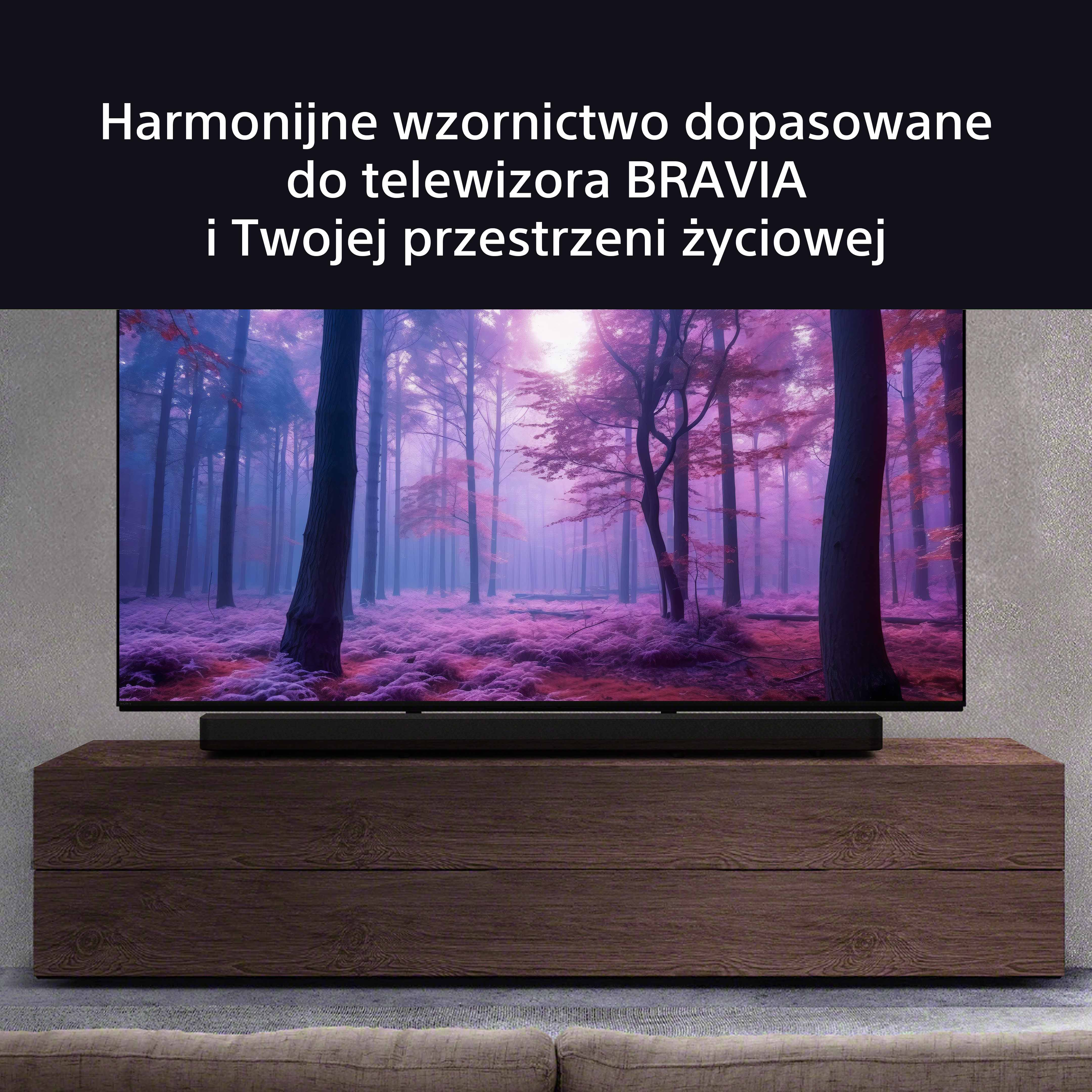 Telewizor z soundbarem na drewnianej szafce, z tłem lasu.