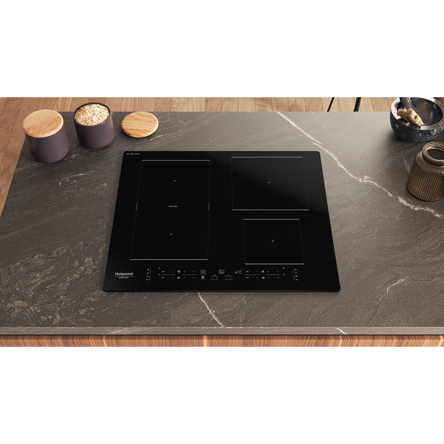 Un piano cottura a induzione nero su un piano di lavoro grigio scuro, vista dall'alto.