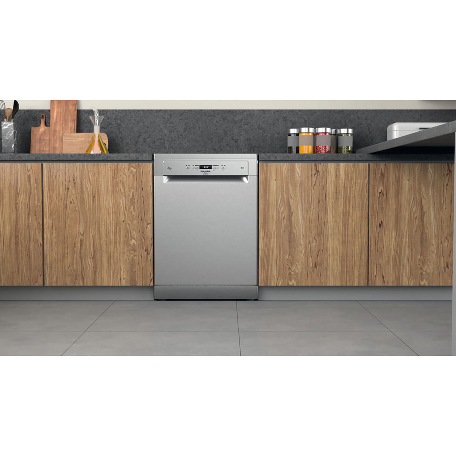 Lavastoviglie in acciaio inox installata in mobili in legno. Pavimento grigio.