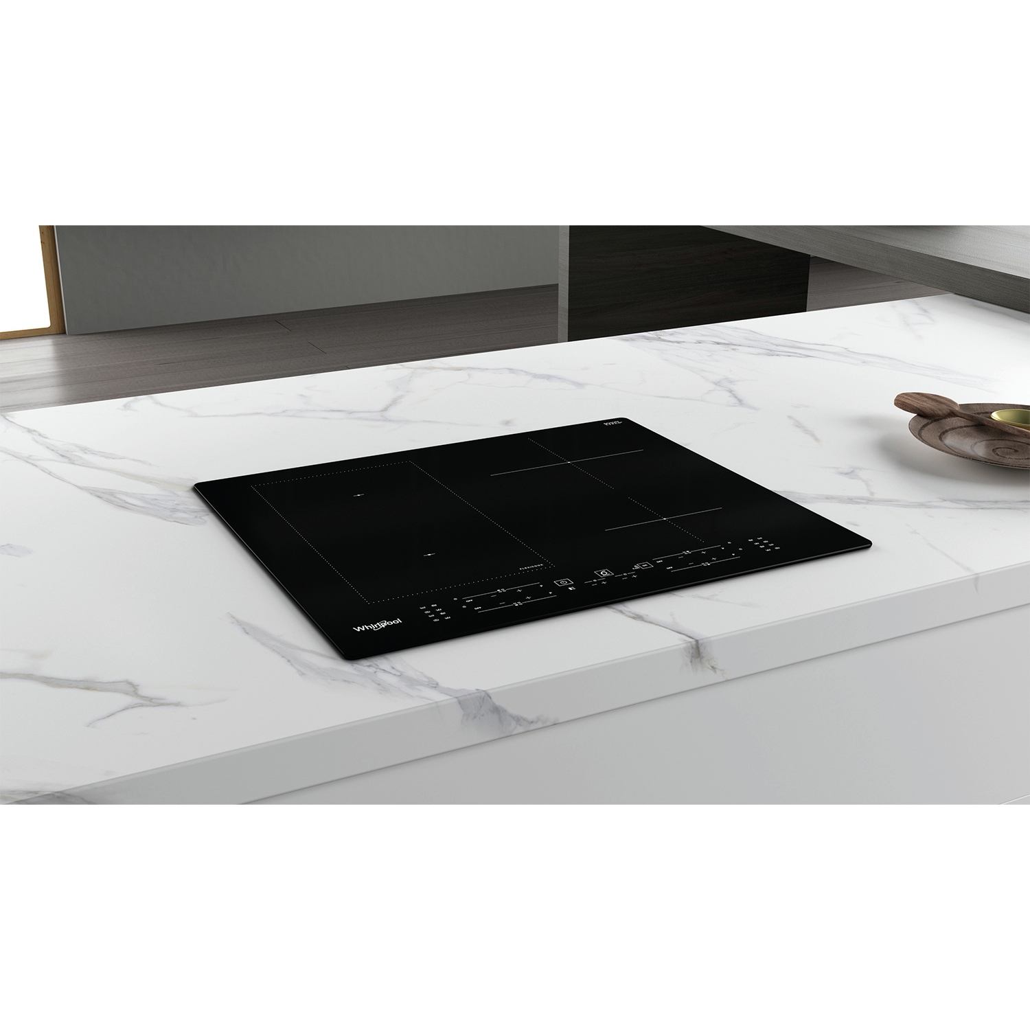 Piano cottura a induzione Whirlpool nero su piano di lavoro bianco, cucina moderna.