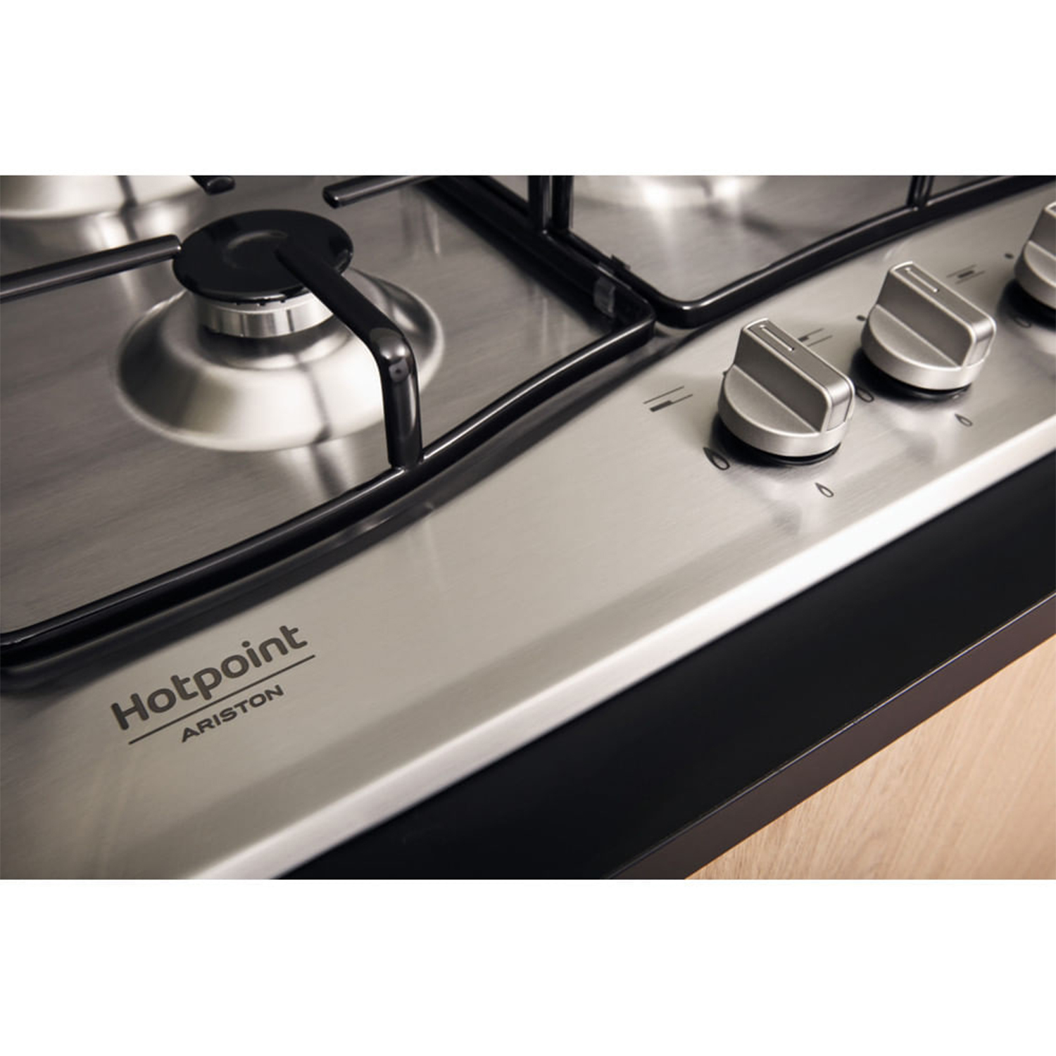 Un piano cottura argentato con manopole nere e il logo Hotpoint Ariston.