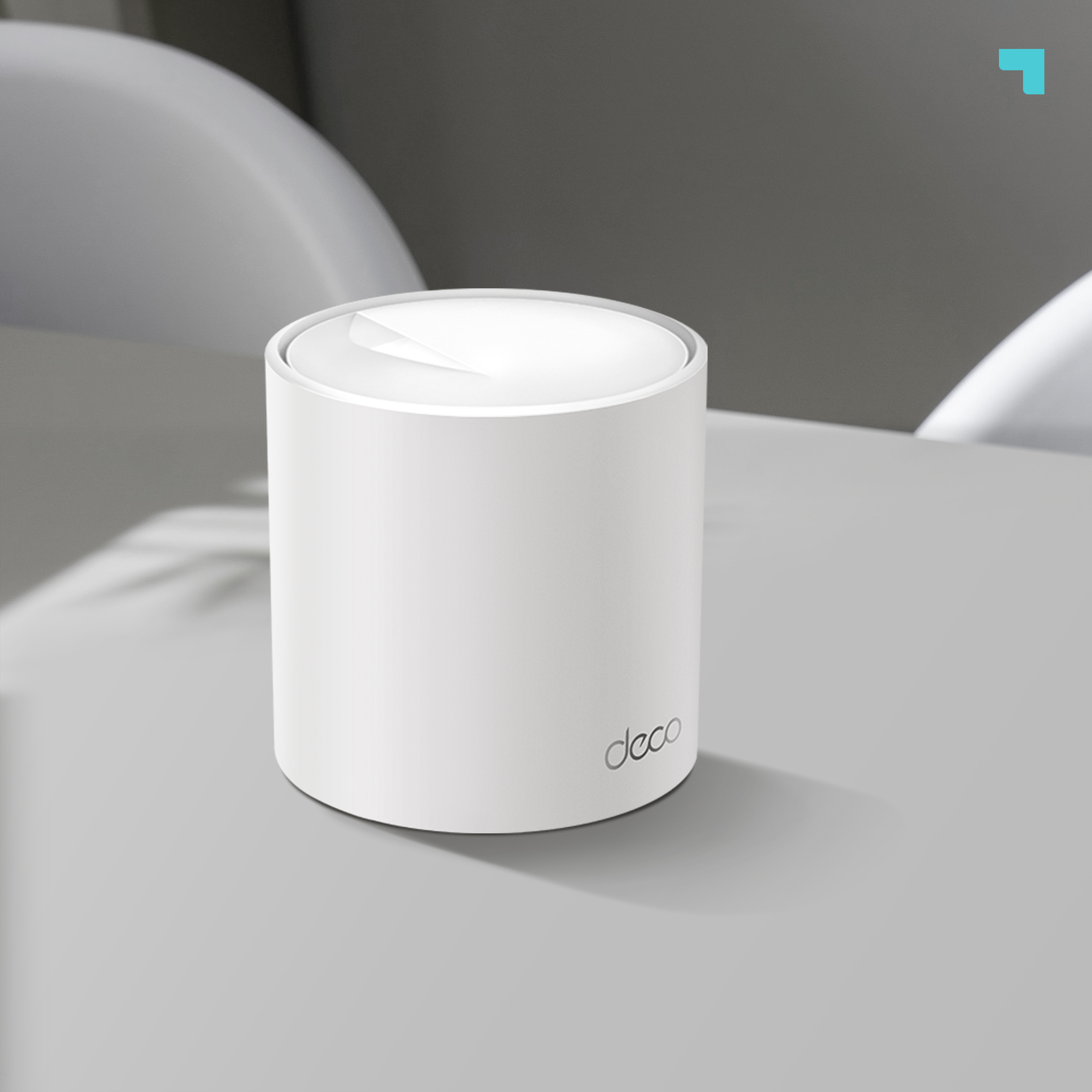 Router Wi-Fi Deco blanco sobre superficie gris, con fondo borroso.