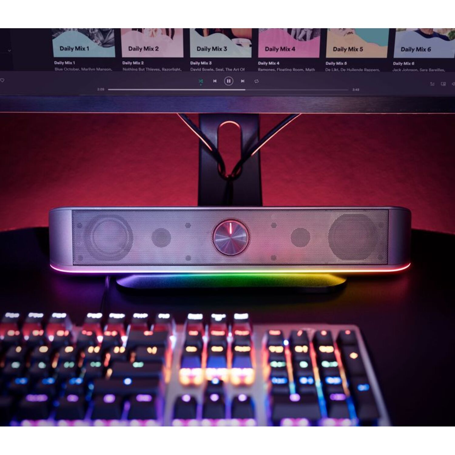 Soundbar with a red button, colorful light, and a keyboard in the foreground.