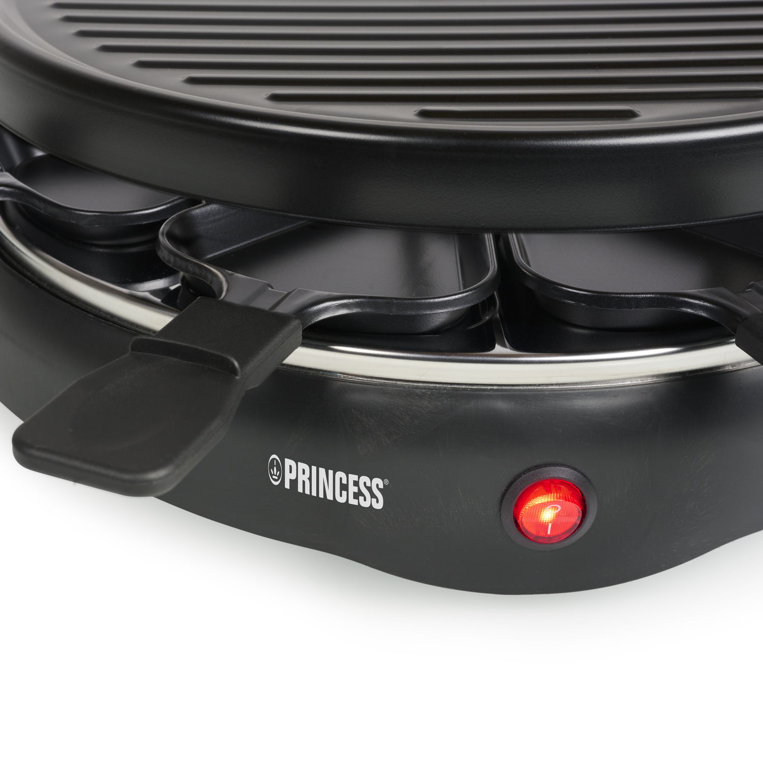 Een zwarte raclette grill met kaaspan, met een rood stroomindicator.