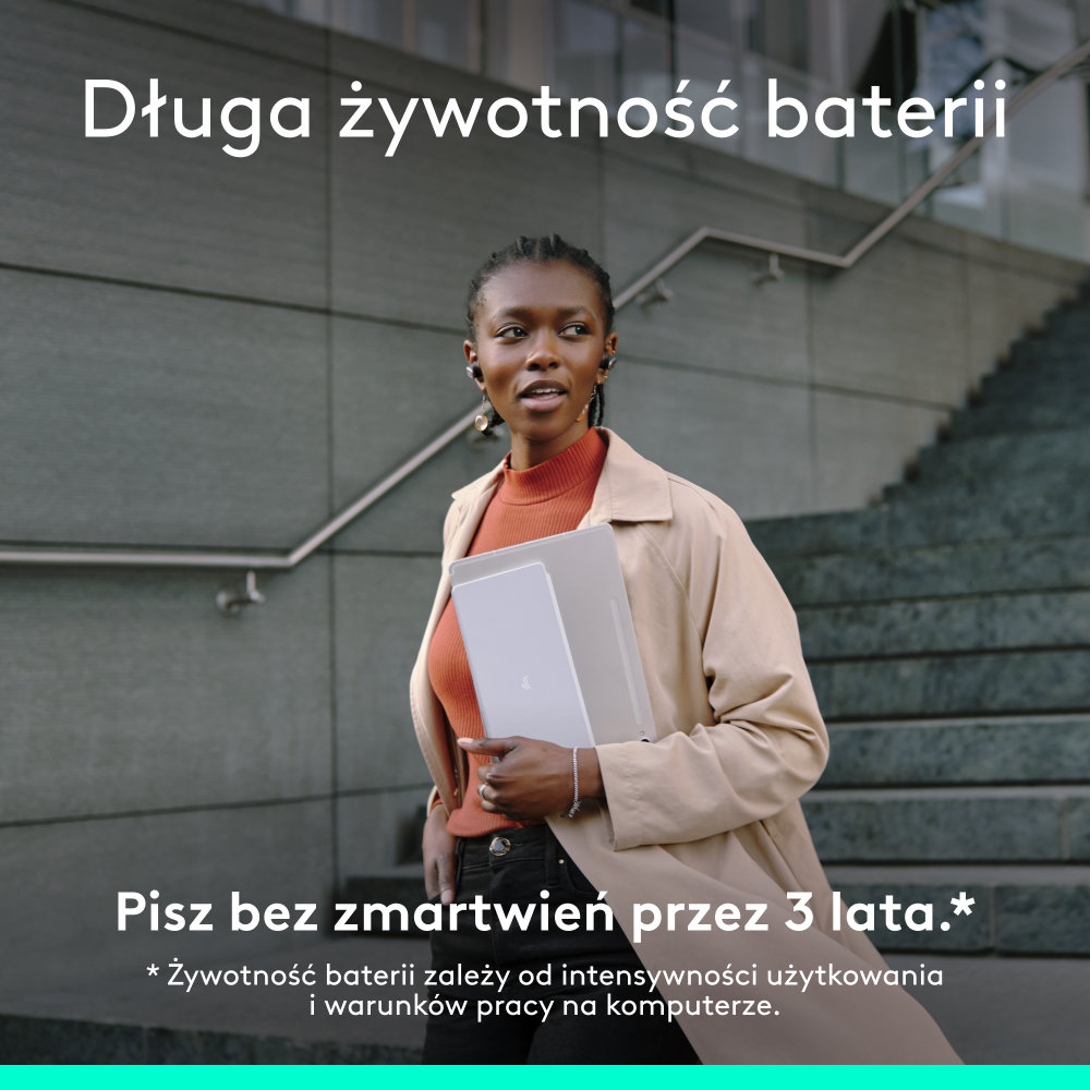 Kobieta z laptopem niesie go, idąc po schodach.