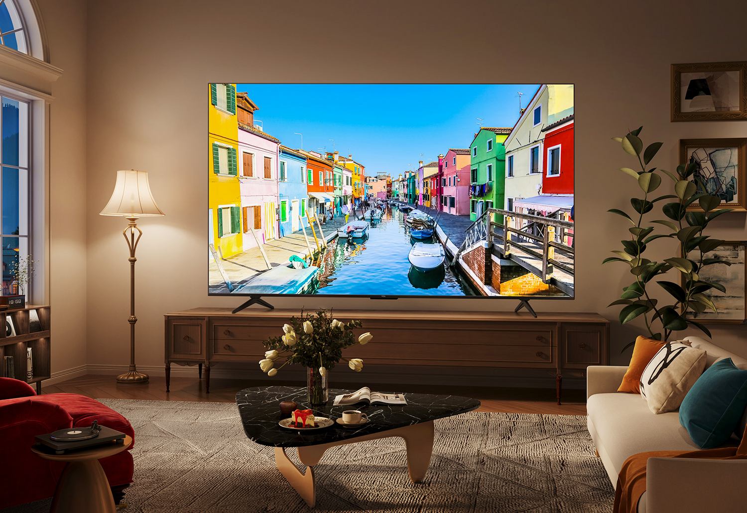 Una gran pantalla de TV muestra una escena de canal colorida. Un salón con muebles está en primer plano.