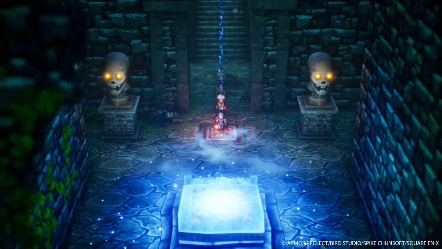 Cámara de piedra iluminada en azul con estatuas de calaveras. Personajes frente a estructura brillante.