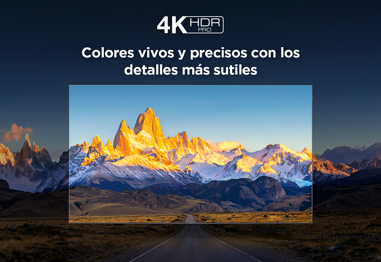 Una cordillera al atardecer con una carretera. El cielo es azul y la luz dorada.