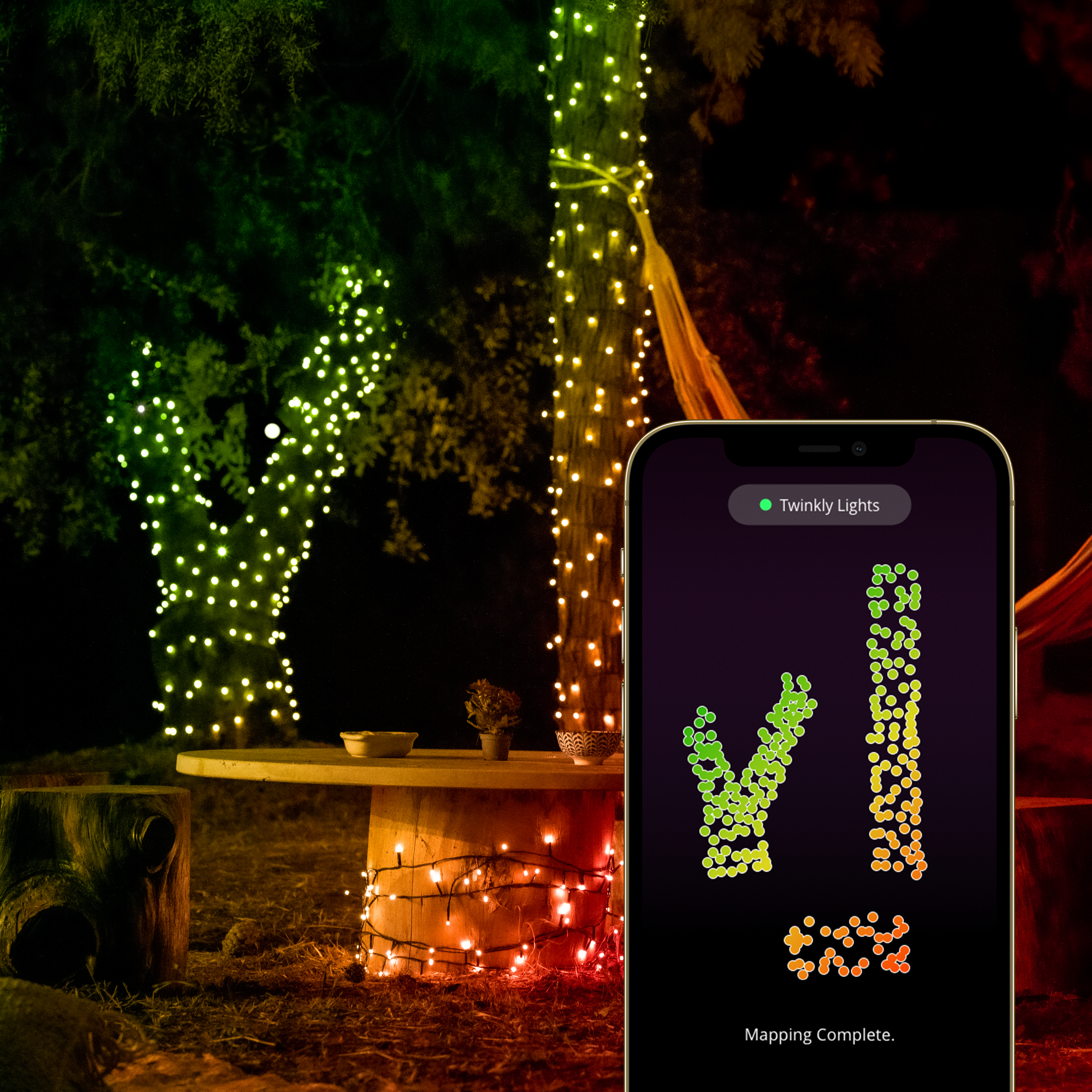 Bäume mit bunten Lichtern, Telefon mit Licht-Mapping und Tisch.