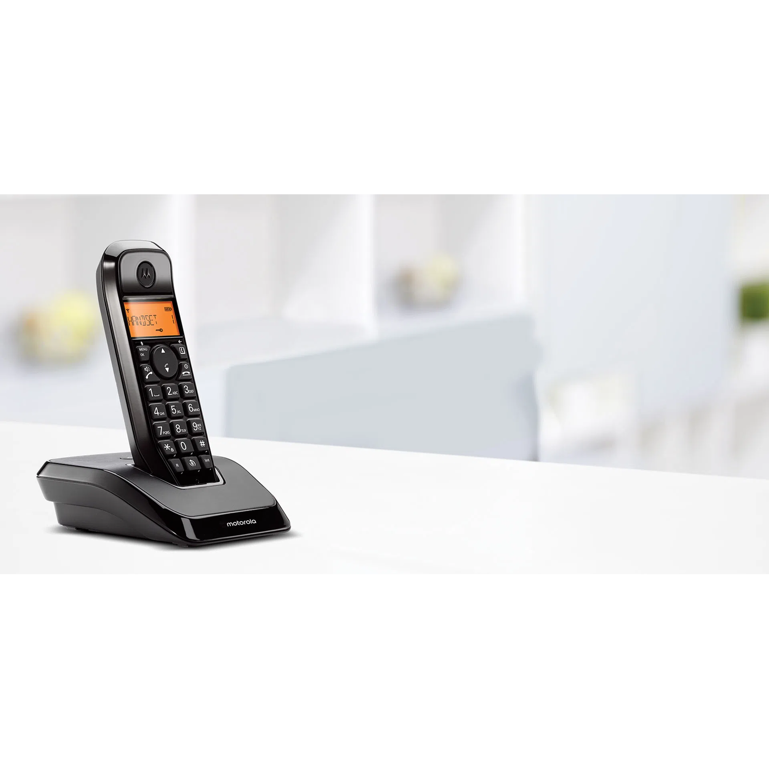 Black cordless phone on a white surface, a white background. Phone has a small screen.